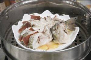 將鱸魚成花狀擺好，將火腿切片放入各縫隙中，放入鍋中隔水蒸12分鐘拿出，撒上蔥花即可。