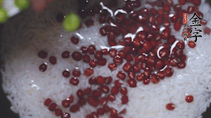 將炒好的食材和大米、紅豆一起放進(jìn)電飯鍋煮。