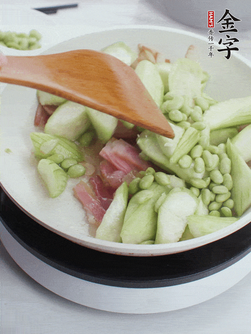 依次下絲瓜、青豆翻炒，炒至絲瓜打蔫縮小。