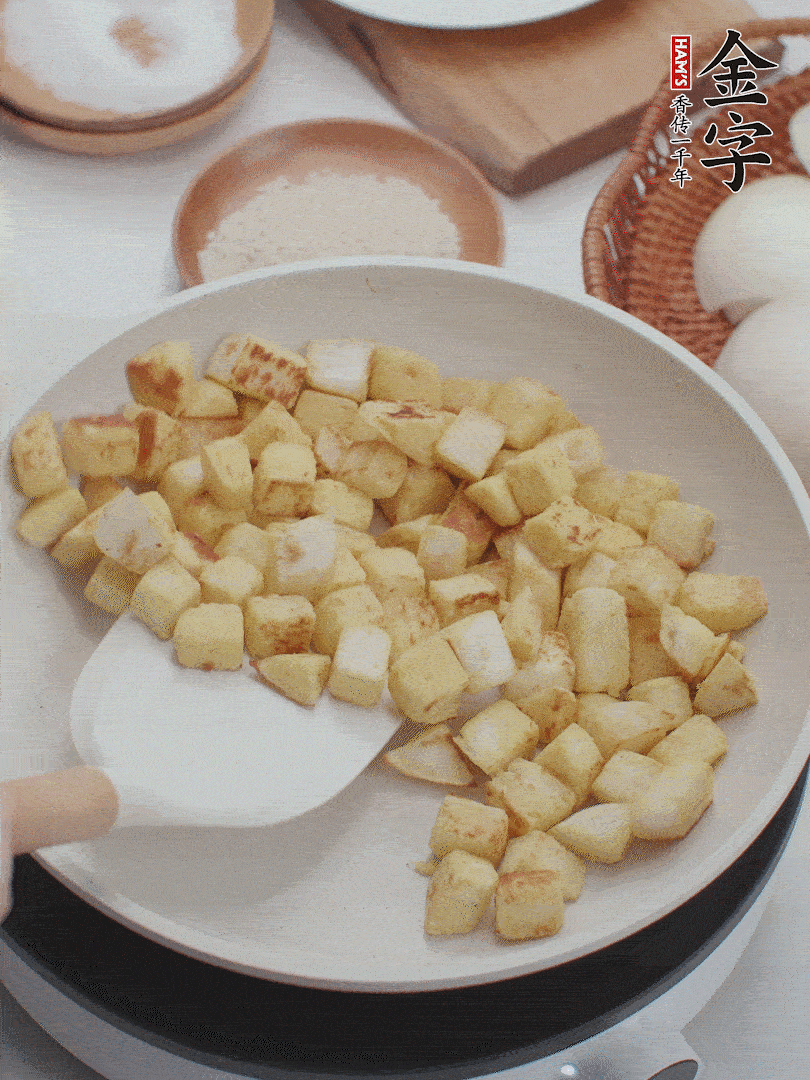 起鍋熱油，倒入饅頭丁，小火煎至蛋液凝固定型再翻面，饅頭丁部煎至金黃時盛起待用。