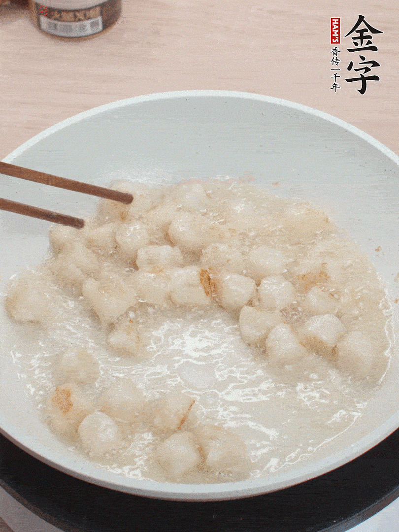 油溫4成熱，鮮貝蘸干淀粉下鍋煎，一面微黃后翻面。