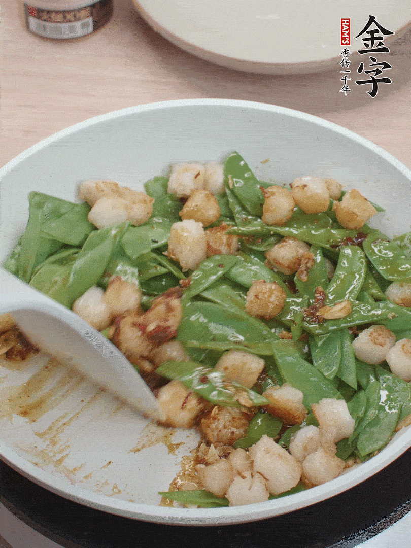 下甜豆莢、鮮貝輕輕翻炒均勻。