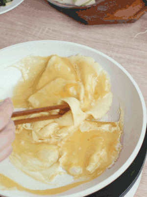 油6成熱時(shí)，下雞蛋液，邊緣凝固時(shí)翻拌成塊狀。