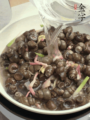 倒處理干凈的螺螄翻炒，加3勺料酒。加清水蓋過螺螄，中火蓋蓋煮5分鐘。