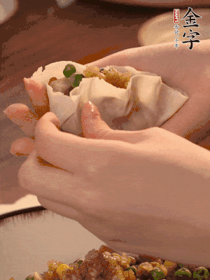 取一大勺餡料放進餃子皮里，用大拇指按住頂部餡料，再用虎口掐出形狀。