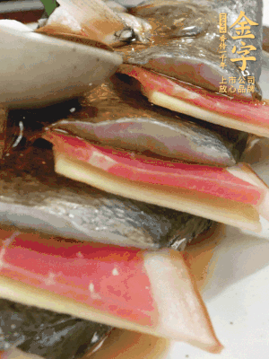 魚肚中塞蔥結(jié)、火腿片，魚身上碼放姜片、火腿片，倒入混合的料汁。
