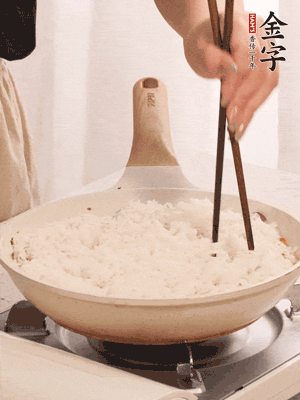 把瀝干水分的米飯均勻鋪在上面，筷子戳幾個洞，以便透氣，轉(zhuǎn)小火蓋上蓋子燜至水分收干，大概10分鐘。